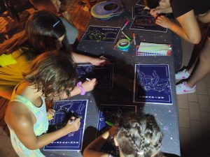 Niños participando en taller astronómico en el paseo de Retamar